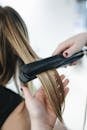 Person Ironing a Woman's Hair